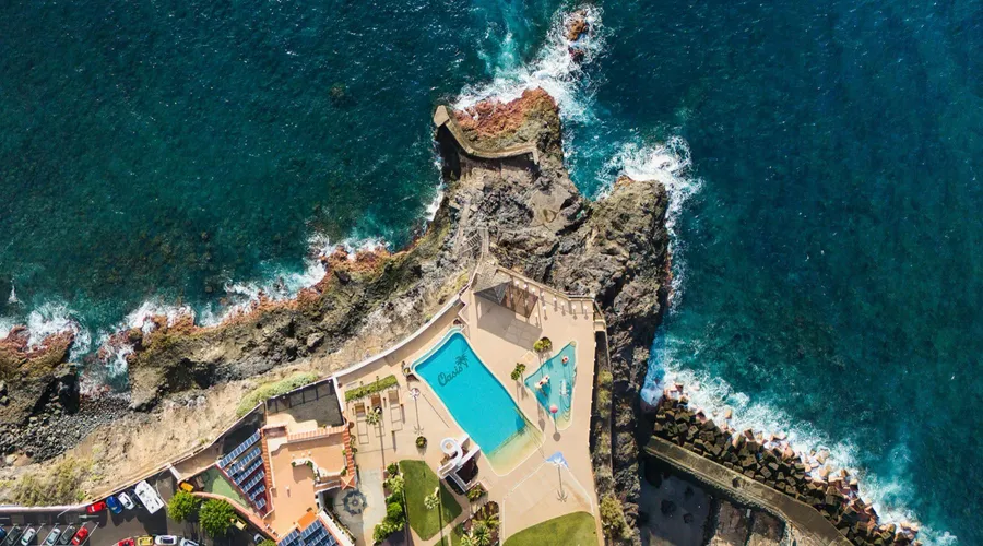 Aerial view of a coastal resort pool beside the ocean