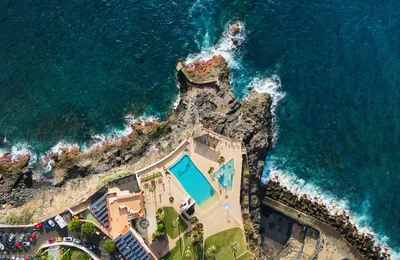 Aerial view of a coastal resort pool beside the ocean